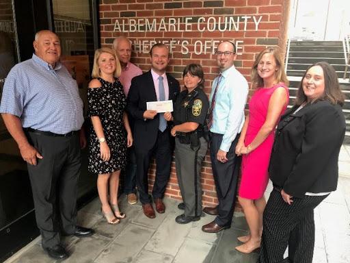 Members of the graduating class of the Virginia Bankers School of Bank Management present a check to Albemarle County Sheriff’s Office Project Lifesaver Program.